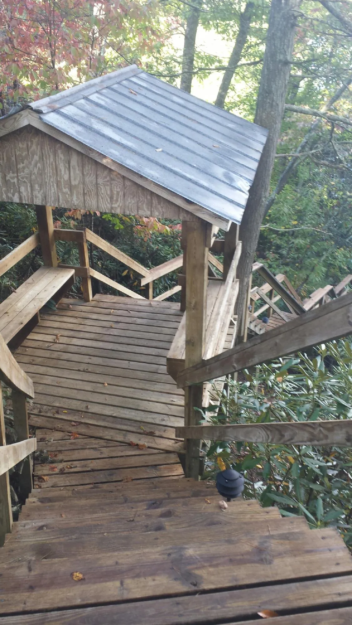 Metal roofed shelter over wooden steps on a wooded walkway — Skylight Repair & Installation work by our crew in Cherryville