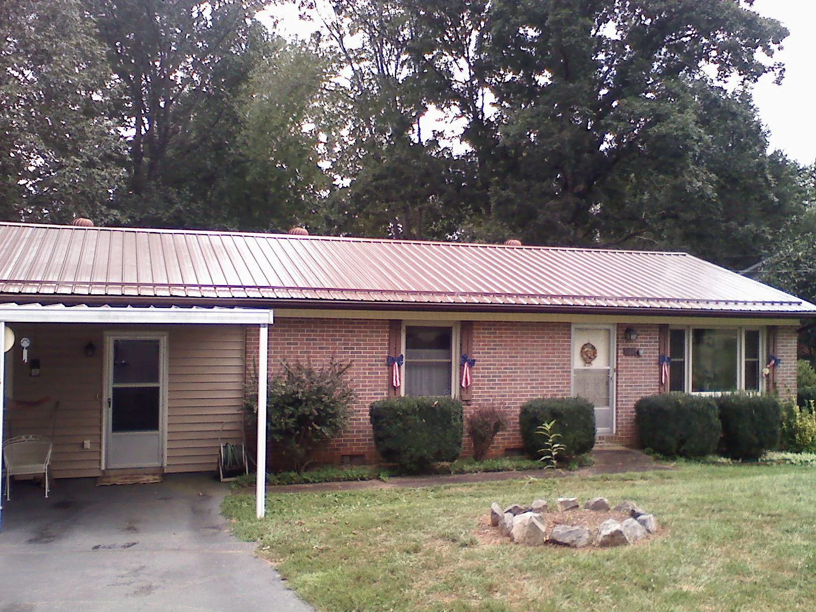 Bronze metal roof and carport on a brick ranch home — Roof Repair work by our crew in Cherryville